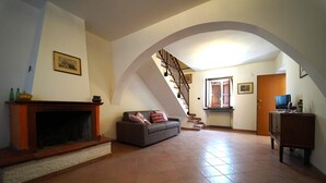 A spacious living area with a fireplace, a sofa, a staircase, and a television. - VILLA ADELAIDE 20Pax, Free WiFi, Private pool near Apuan Alps and Cinque Terre (Toscana)