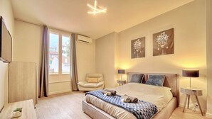A modern bedroom with a large bed, a chair, a desk, and artwork on the walls. - Croisette -palais festival-Citycenter -confortable, Croisette - palais festiva l- Citycenter  (Cannes)