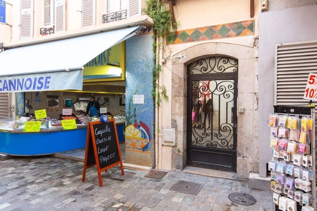 Un stand de restauration de rue avec une enseigne indiquant « Coquille Oursin Lou Pasteur » et un panneau noir annonçant « Coquille Oursin Lou Pasteur ».