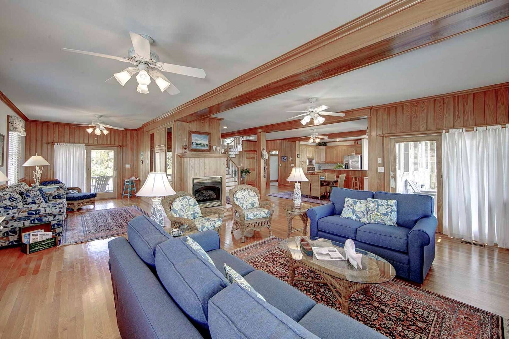A spacious living room with a fireplace, two sofas, a coffee table, and a dining area.