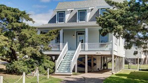 A two-story house with a porch and a staircase leading to a covered area. - The Dory - Ocracoke Island (Ocracoke)