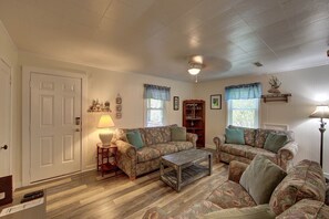 Traditional living room with a classic door, two patterned sofas, a wooden coffee table, and a floor lamp.