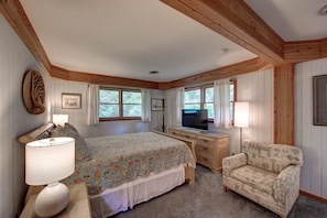 Relax in this traditional bedroom with a plush bed, desk, and armchair.