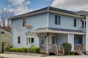 Ein zweigeschossiges Haus mit Veranda, kleinem Garten und Garage.