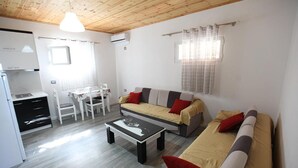 En moderne stue med sofa, sofabord og spiseplads med bord og stole.