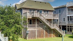 A two-story wooden building with a balcony and a staircase leading to the upper floor.