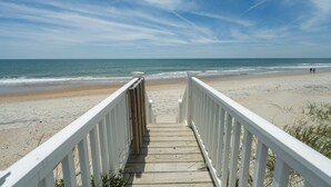 A wooden boardwalk leading to a beach with a white railing on both sides. - New River Inlet Rd. 650 (North Topsail Beach)