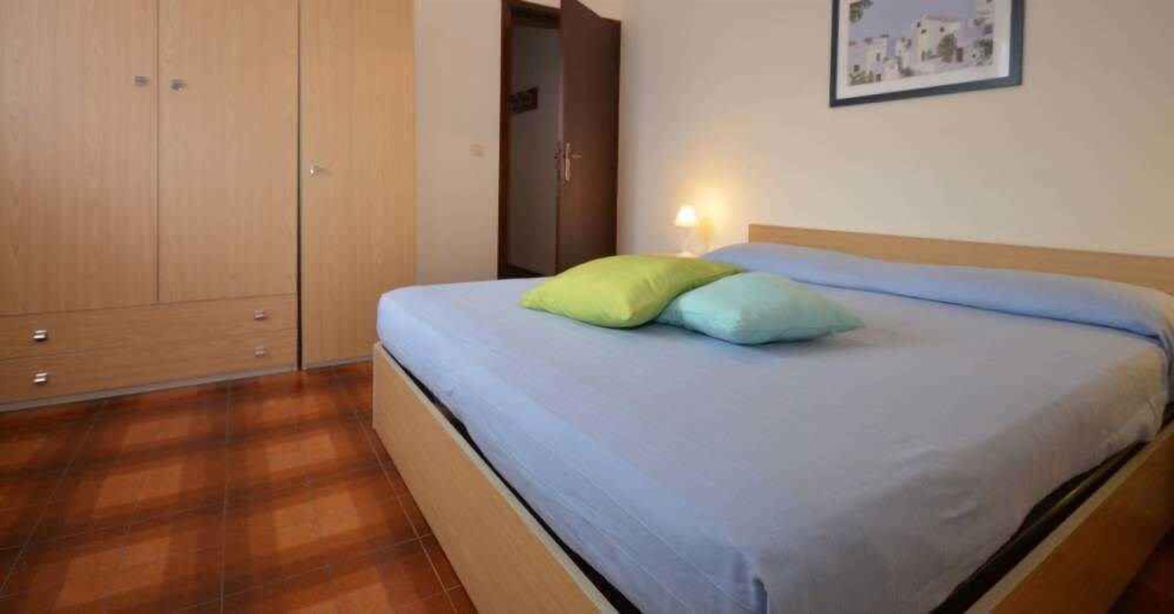 Un dormitorio con cama, armario y puerta.