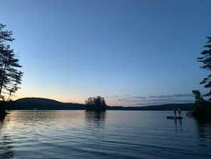 A calm lake with a dock and two people standing on it. - Modern Lake House on Secluded Cove with Private Peninsula  (Enfield)