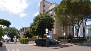 Un edificio moderno con diversi piani, un segnale che indica un'area di parcheggio privata e un cielo sereno.