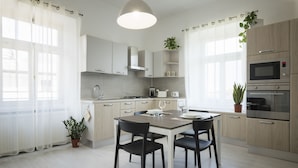 Una cucina moderna con isola centrale, mobili bianchi ed elettrodomestici in acciaio inossidabile.