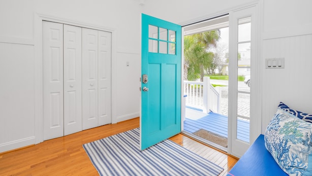 A room with a turquoise door, white closet, wooden flooring, and a blue and white striped rug. - Contemporary Beach Home Near Back River for the Whole Crew by Tybee Cottages (Tybee Island)