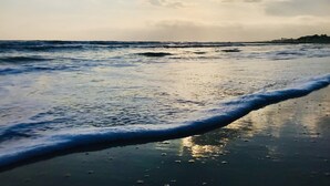 Una playa con olas suaves que llegan a la orilla.