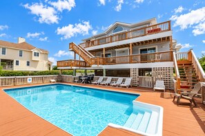 A two-story building with a swimming pool, outdoor seating, and a wooden deck. - Time to Chill - Corolla, Whalehead, Ocean View, 480 Yds to Beach, Pool, Flex Stays (Corolla)