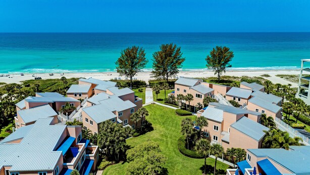 Una località balneare con diversi edifici, una spiaggia e cieli azzurri.