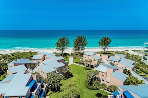 A coastal resort with multiple buildings, a beach, and clear blue skies. - Unit #101 Sand Cay, Gulf View, Steps to Beach, Recently Remodeled (Longboat Key)