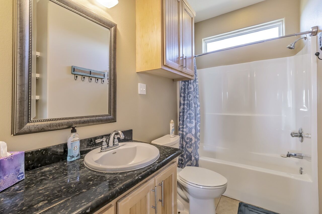 A bathroom with a sink, toilet, and bathtub.