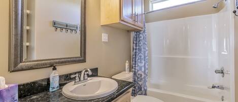 A bathroom with a sink, toilet, and bathtub.