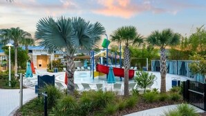 Un parc aquatique avec une rivière à courant doux, des palmiers et un bâtiment doté d’un toit bleu.