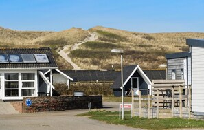 A building with a solar panel roof, a wheelchair-accessible ramp, and a sign indicating a wheelchair-accessible entrance. - Lovely home in Hvide Sande (Hvide Sande)