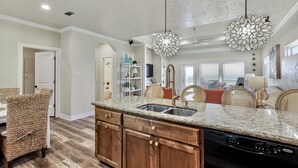 A kitchen with granite countertops, wooden cabinets, and a built-in dishwasher. - ALL DECKED OUT - 2 Bedroom, 2 Bath, Sleeps 6 - Beach Front! (Crystal Beach)