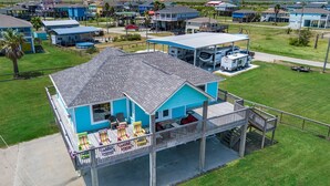 Une maison située sur la côte, dotée d’une terrasse couverte et d’une remorque pour bateau.