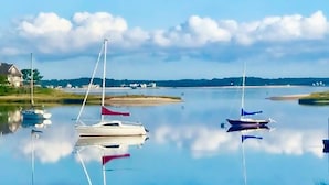 Un lago tranquilo con varias embarcaciones ancladas.