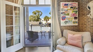 Una habitación con puerta de vidrio corredera que da a un patio exterior con mobiliario de mimbre y una mesa.