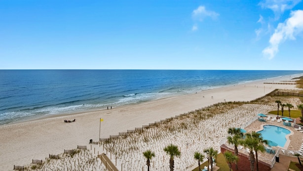 Un resort en la playa con piscina, zona de playa y vistas despejadas al océano.