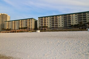 A beachfront hotel with multiple balconies, a sandy beach in front, and a clear sky. - Sandy Key 534: 2 BR / 2 BA Gulf Front Condo in Perdido Key, FL. Sleeps 6 (Pensacola)