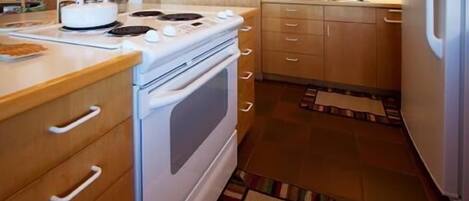 A kitchen with a stove, oven, microwave, and refrigerator.