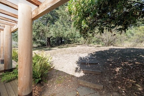 Eine Holzterrasse mit einem Kiesweg, der zu einem Holzgebäude führt.