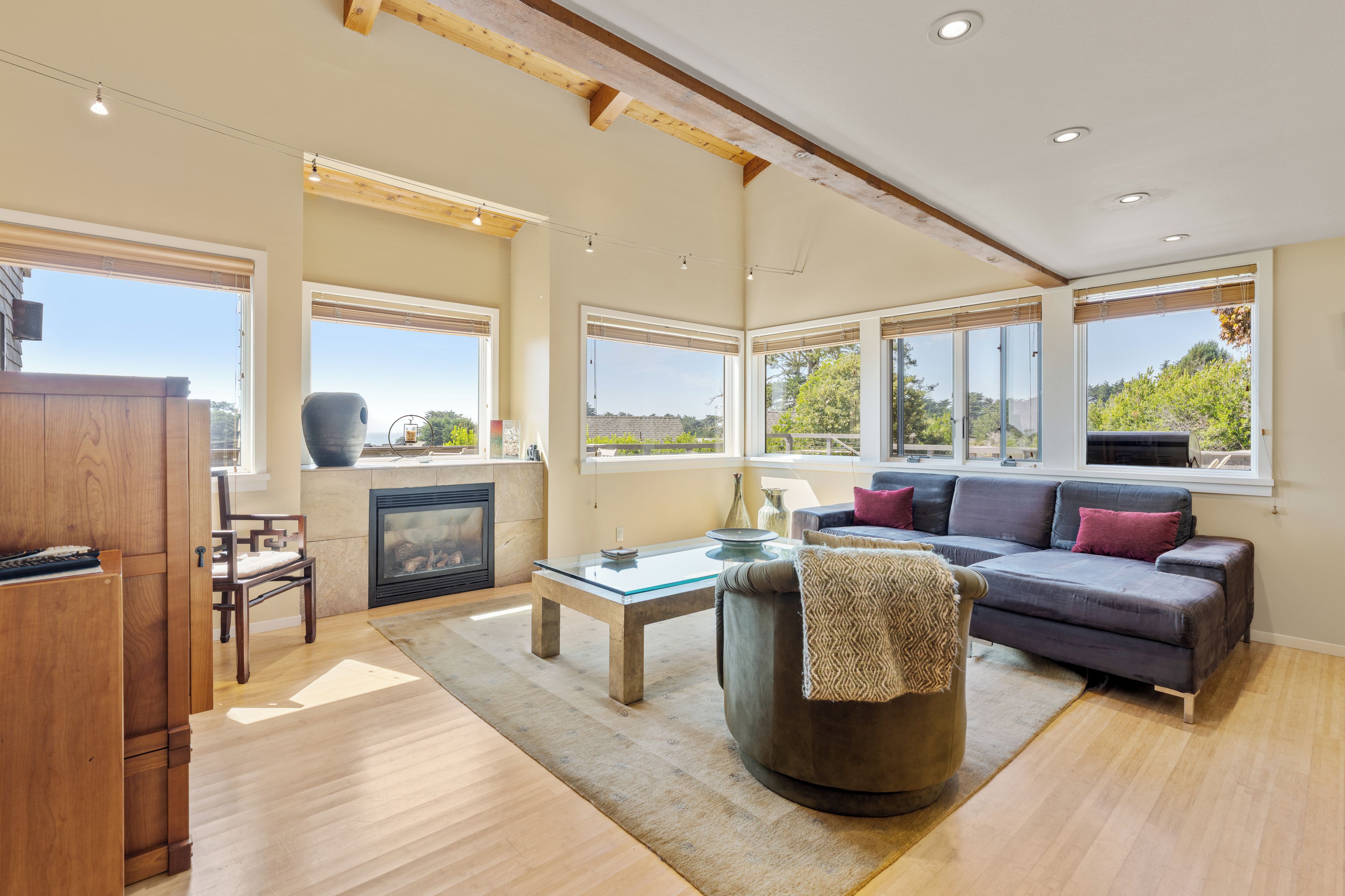 Una sala de estar amplia con chimenea, ventanas grandes y una zona de estar acogedora.