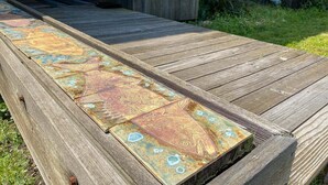 Une terrasse en bois ornée de motifs géométriques en carreaux.
