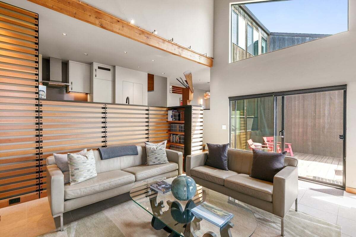 A modern living room with a sofa, coffee table, and a bookshelf.