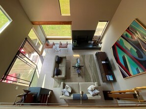 A modern living room with a sofa set, a coffee table, and a painting on the wall.