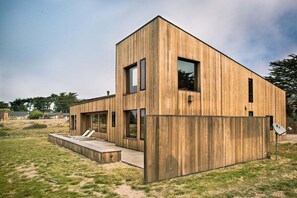 A modern wooden house with a flat roof, large windows, and a deck. - Horizon Reach - Black Point Beach Views (Sea Ranch)