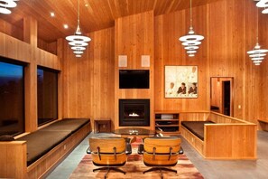 Een houten interieur met een open haard, zitplaatsen en een televisie.