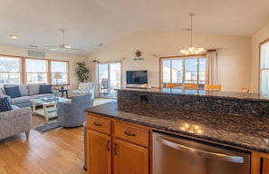 A modern kitchen with granite countertops, wooden cabinets, and a built-in dishwasher.