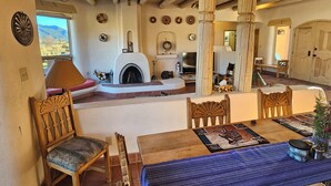 Un salon chaleureux avec une cheminée, des meubles en bois et une vue sur l’extérieur.