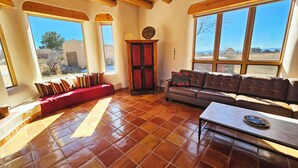 A spacious living room with a red sofa, a brown leather couch, and a tiled floor. - Casa Luminosa, Private Hot Tub Los Altos Clubhouse with pool, sauna, tennis (Arroyo Seco)