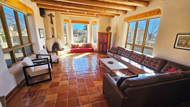 A spacious living room with a fireplace, large windows, and a high wooden ceiling. - Casa Luminosa, Private Hot Tub Los Altos Clubhouse with pool, sauna, tennis (Arroyo Seco)