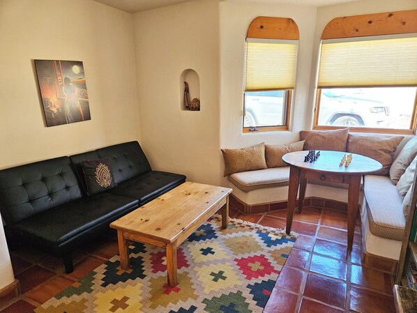 A cozy living room with a black sofa, a wooden coffee table, a patterned rug, and a small round table with chess pieces. - Casa Luminosa, Private Hot Tub Los Altos Clubhouse with pool, sauna, tennis (Arroyo Seco)