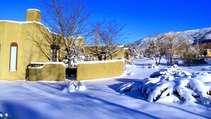 A snow-covered landscape with a yellow building featuring a window and a door. - Casa Luminosa, Private Hot Tub Los Altos Clubhouse with pool, sauna, tennis (Arroyo Seco)