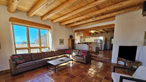 A spacious living area with a large sofa, a coffee table, and a TV on a stand. - Casa Luminosa, Private Hot Tub Los Altos Clubhouse with pool, sauna, tennis (Arroyo Seco)