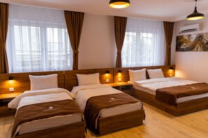 Habitación cuádruple Deluxe | Ropa de cama de alta calidad y escritorio
