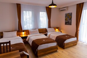 Habitación triple de diseño | Ropa de cama de alta calidad y escritorio