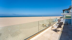 A balcony with a glass railing overlooking a beach. - 3525O - Big Blue Beauty: 3  BR, 5  BA House in Oxnard, Sleeps 6 (Oxnard)