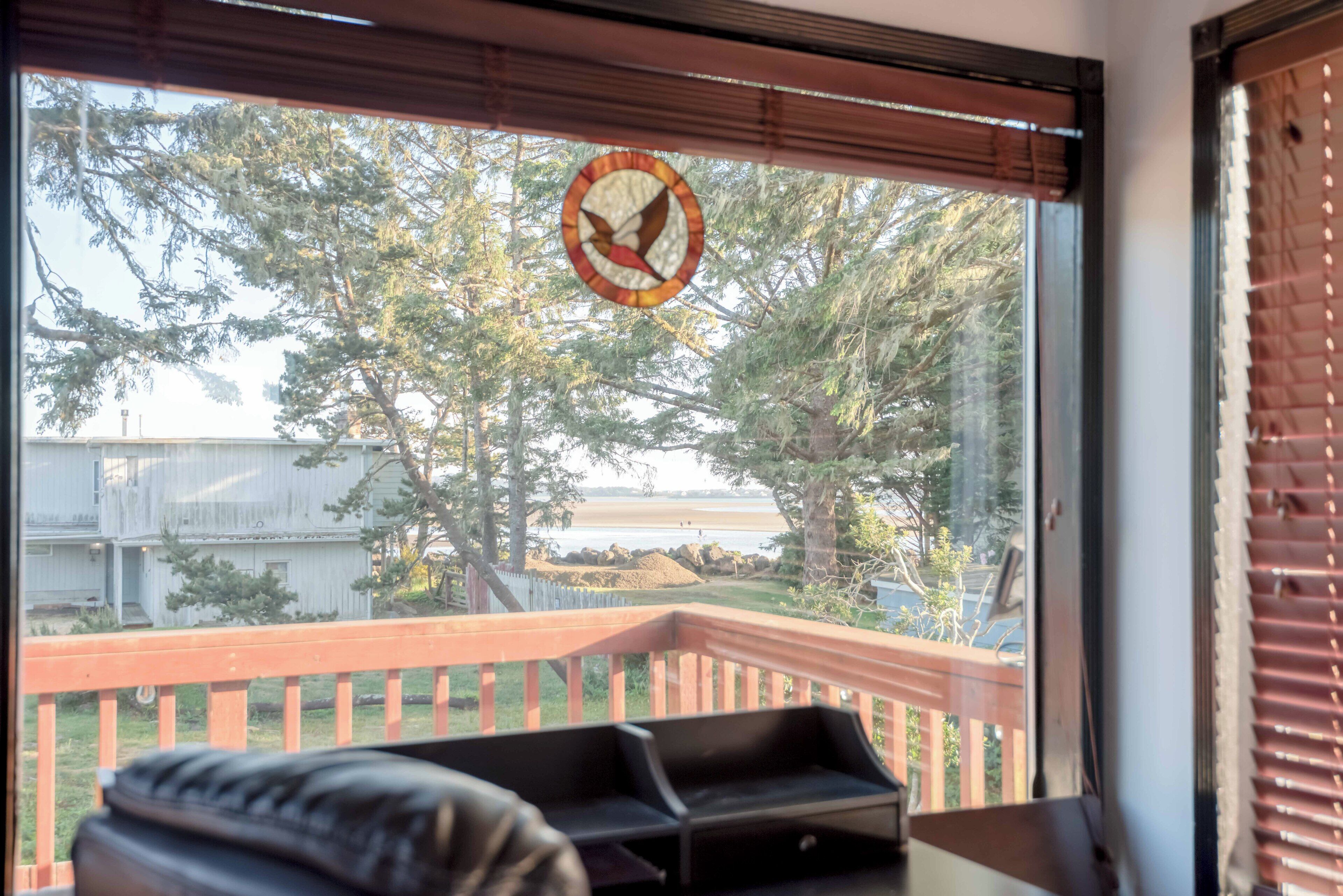 Une chambre avec vue sur une terrasse en bois et des arbres.