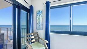 A room with a view of the ocean, a wooden chair, and a painting on the wall. - Horizon East 804 - Two Bedroom, Two Bath Oceanfront Condo (Garden City Beach)